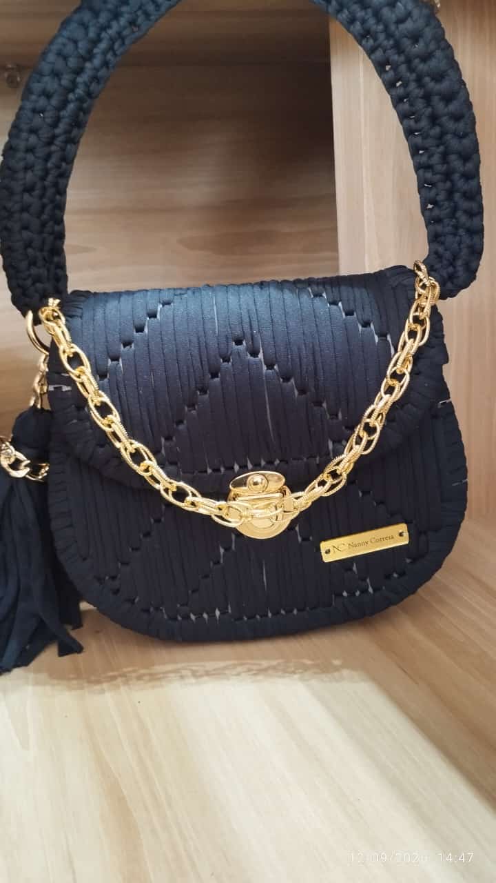 Bolsa artesanal preta arredondada com corrente dourada